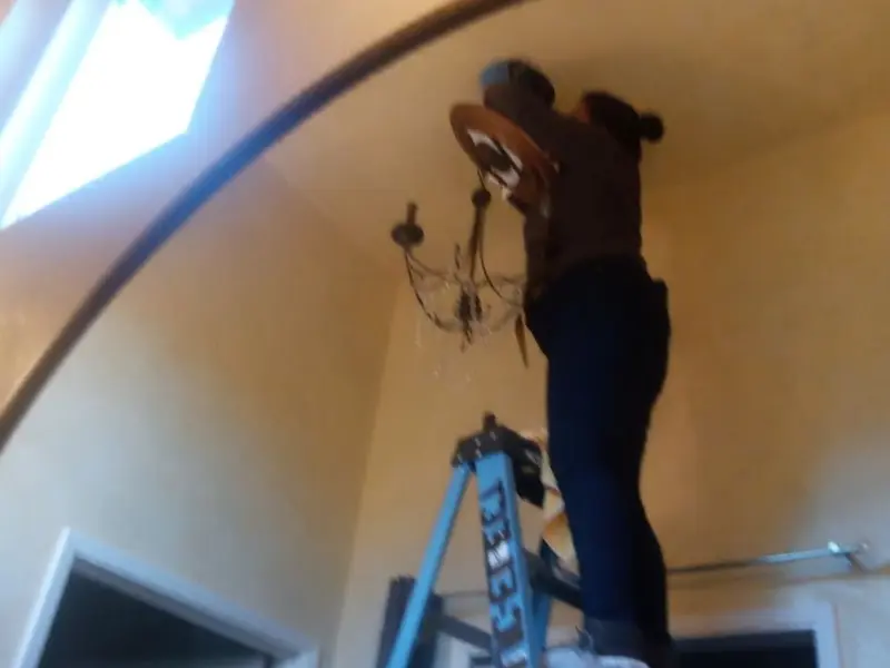 Electrician installing a chandelier in a La Junta residence